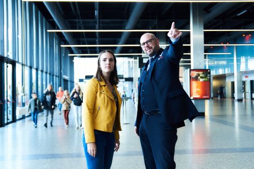 Mannelijke beveiliger in uniform wijst aan een vrouwelijke voorbijganger de weg op Jaarbeurs Utrecht.