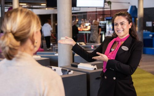 Medewerkster van Embrace wijst vrouwelijke bezoeker de weg.