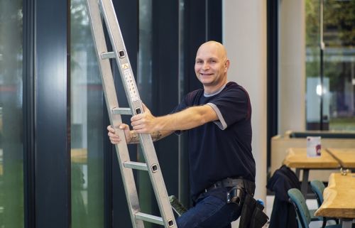 Glazenwasser zet een ladder tegen de binnengevel