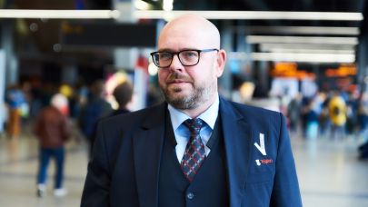 Mannelijke beveiliger in uniform loopt in de centrale hal van de Jaarbeurs Utrecht.